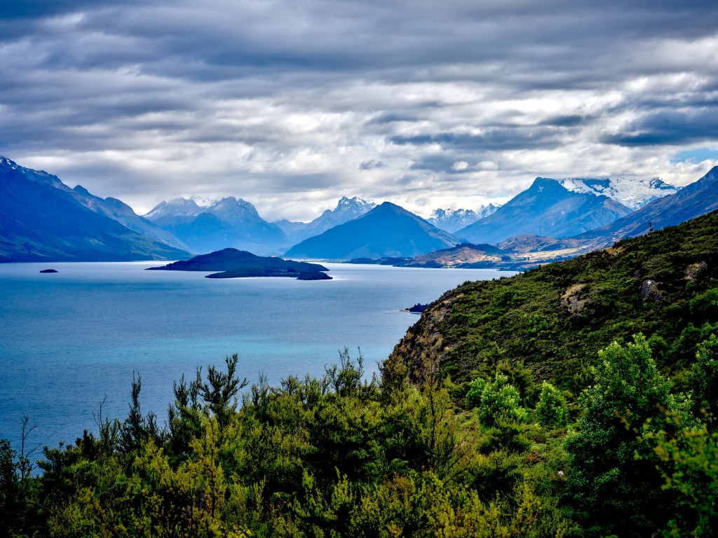 New Zealand 53 Layered mountains rise beyond blue lake water at the northern end near Queenstown.