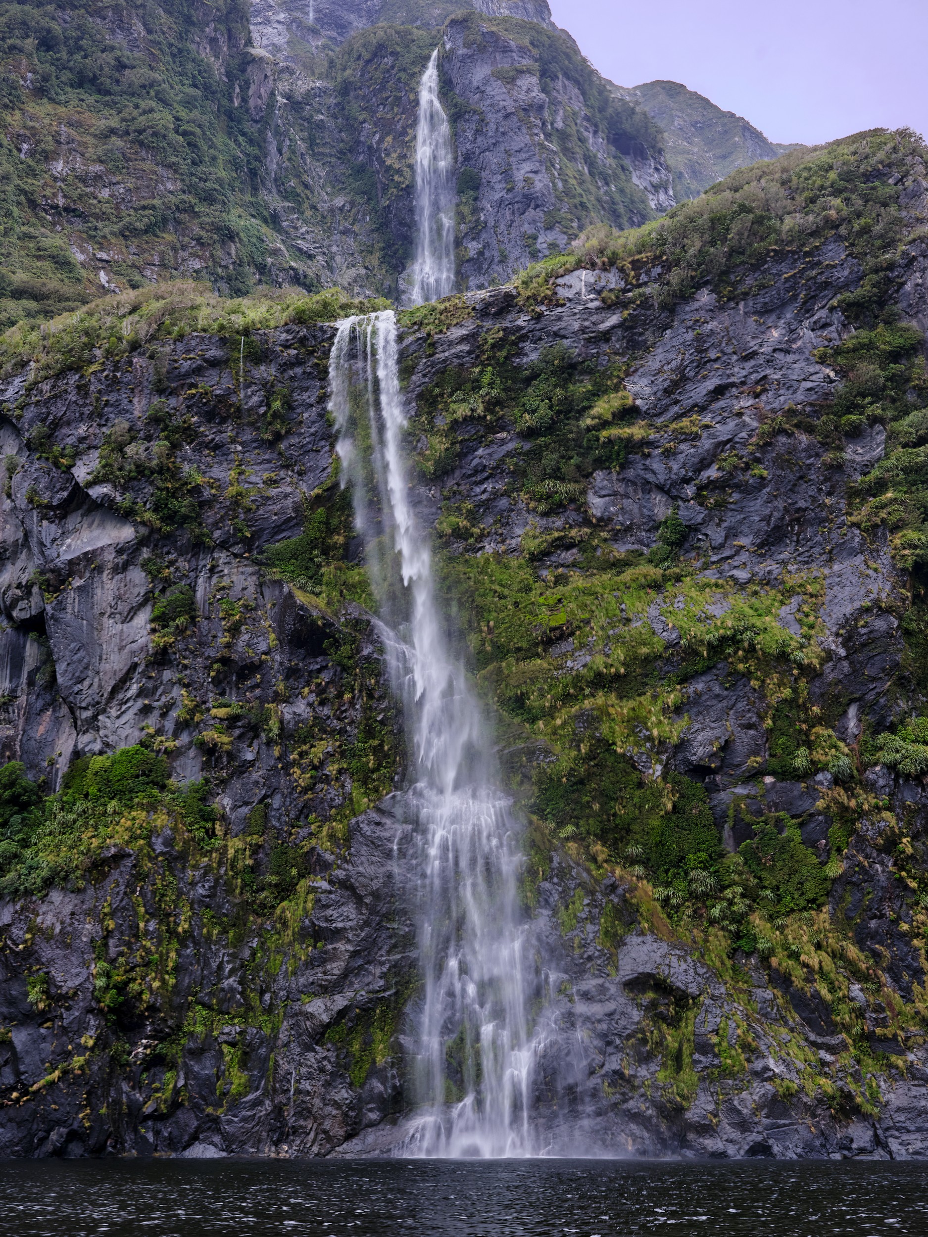 Milford Sound 28 A rain-fed waterfall drops in two stages down a mossy cliff face near Milford Sound.