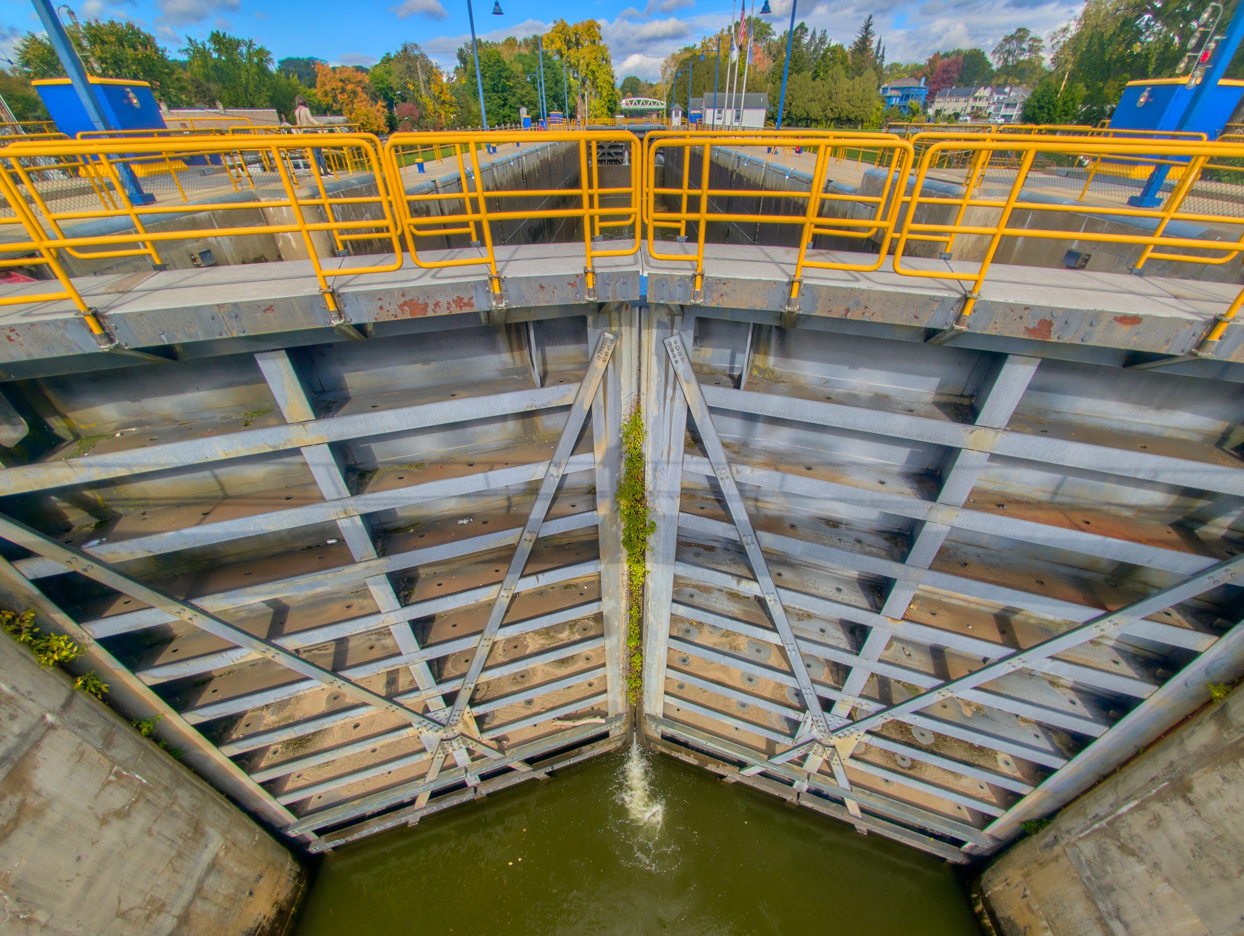 Vermont and Quebec 64 Looking down between gray steel lock gates with yellow railings above green canal water.
