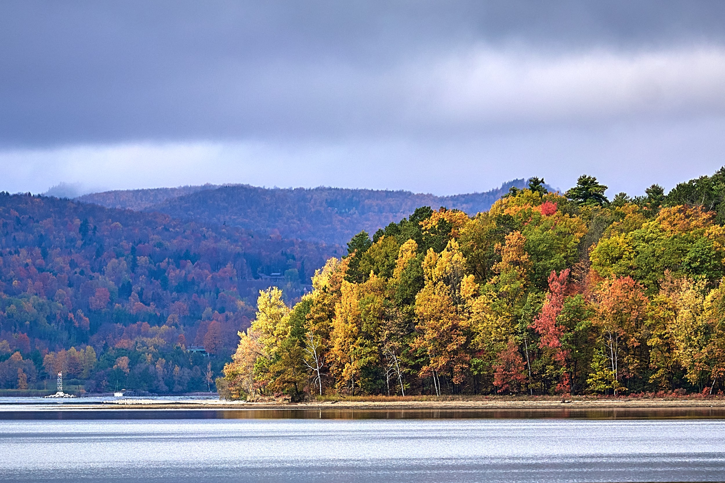 Vermont and Quebec 10 Bright deciduous trees and dark pines form a peninsula extending into steel-blue Lake Memphremagog.