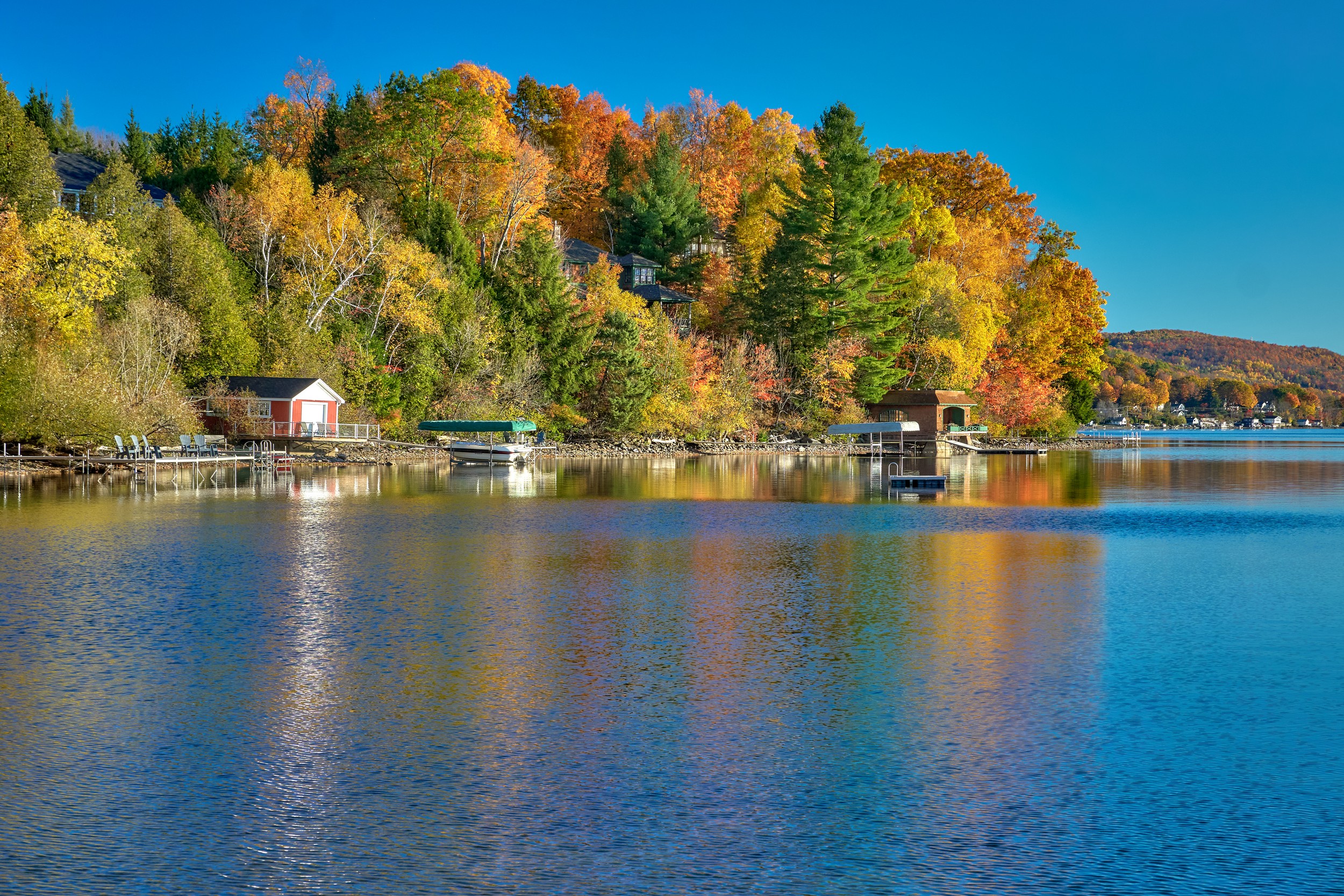 Vermont and Quebec 72 Colorful shoreline homes and small docks sit across calm Lake Massawippi beneath forested hills.