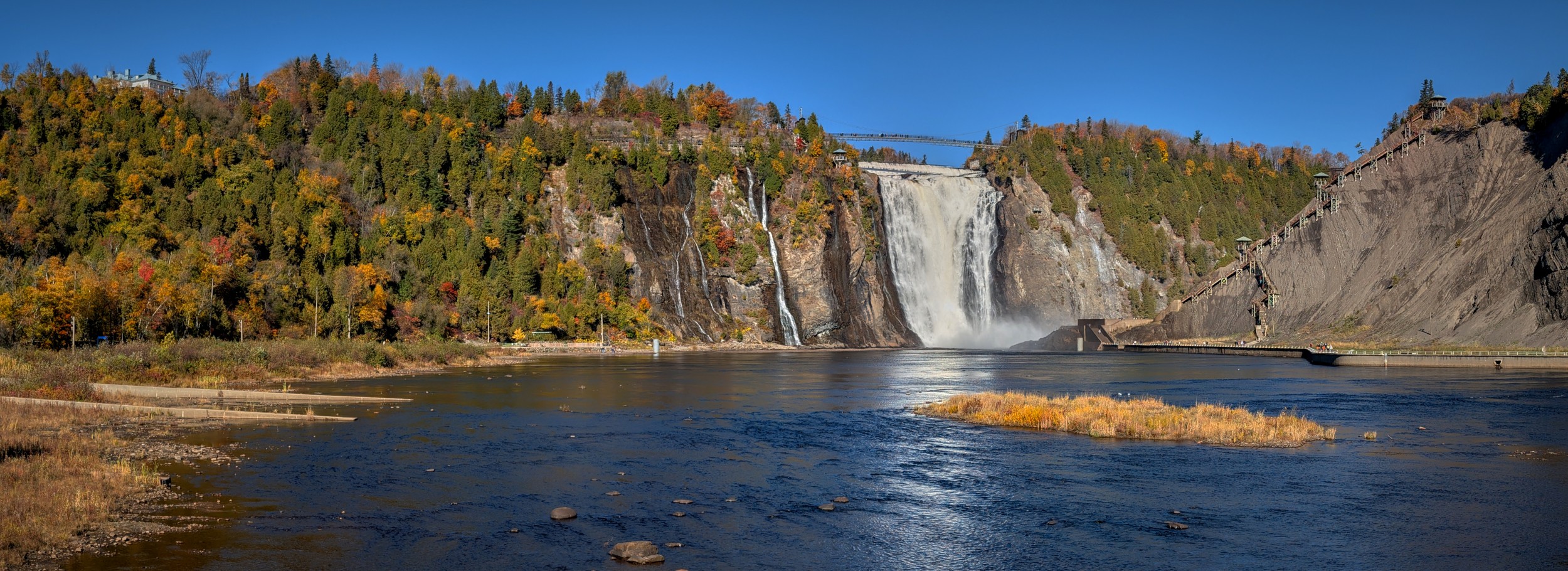 Vermont and Quebec 1 Wide view of a waterfall between limestone walls, with calm dark water downstream and autumn trees along the cliff tops.